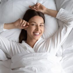 woman in bed with a big smile