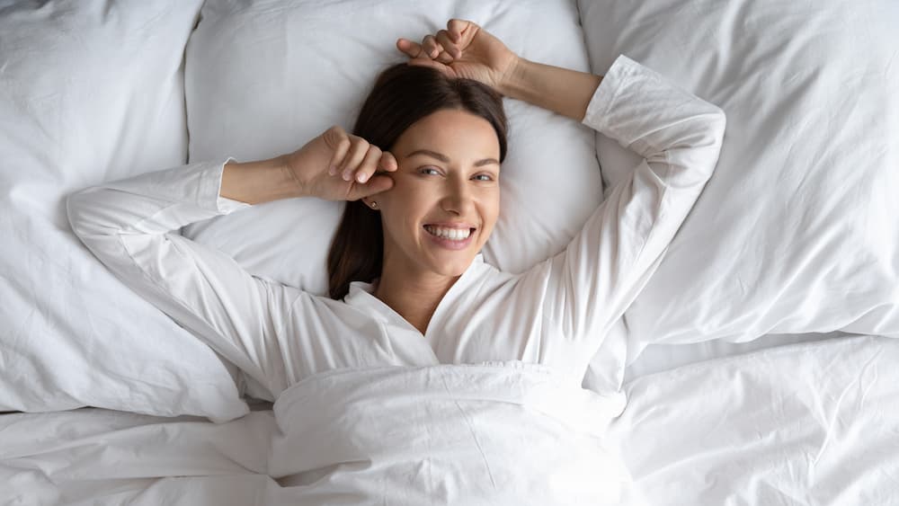 woman in bed with a big smile